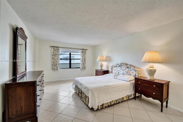 bedroom with a textured ceiling and light tile patterned floors