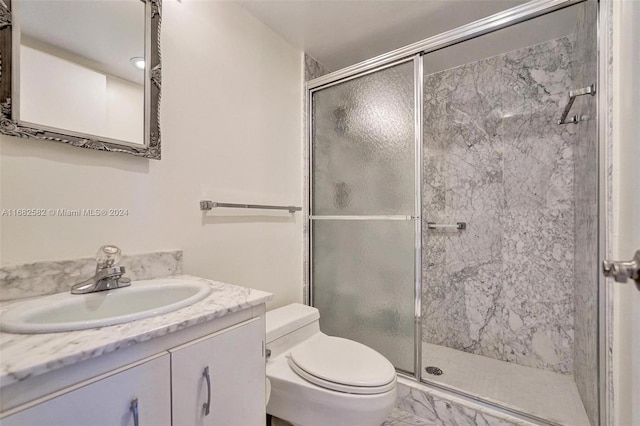 bathroom with walk in shower, vanity, and toilet