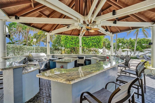 view of patio with an outdoor bar, a grill, a gazebo, and exterior kitchen