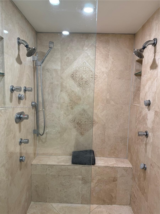 bathroom featuring tile patterned flooring and a tile shower