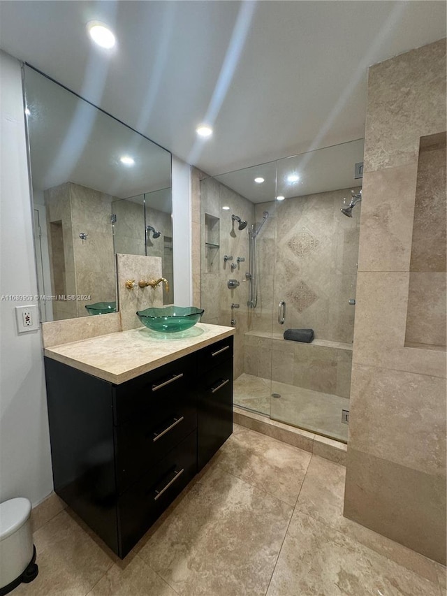 bathroom featuring tile patterned flooring, an enclosed shower, and vanity