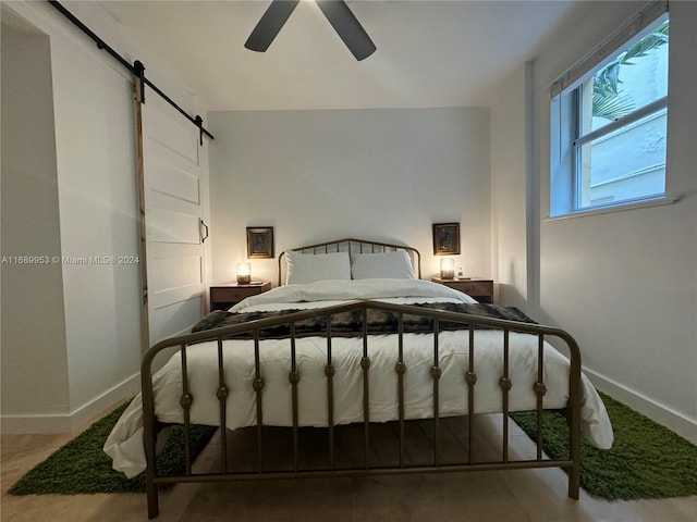 bedroom featuring a barn door and ceiling fan