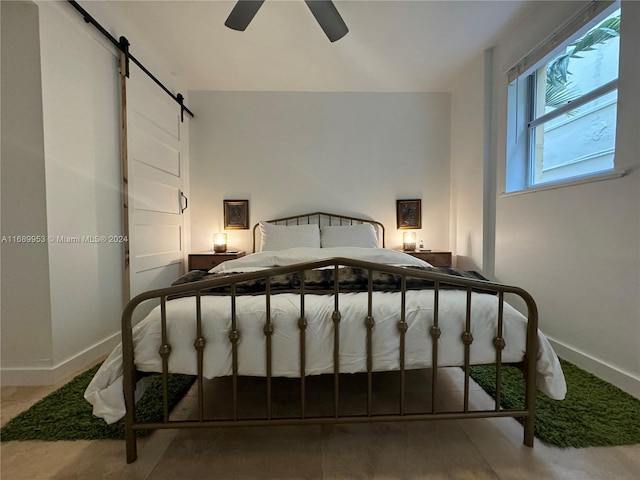 bedroom with a barn door and ceiling fan