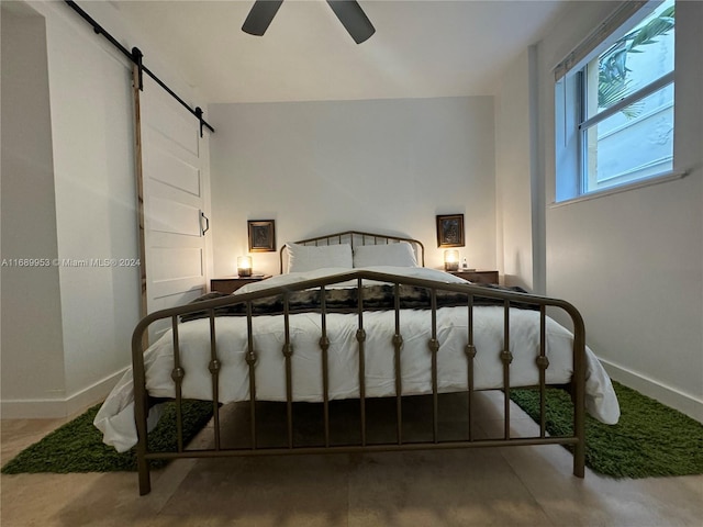 bedroom with a barn door and ceiling fan