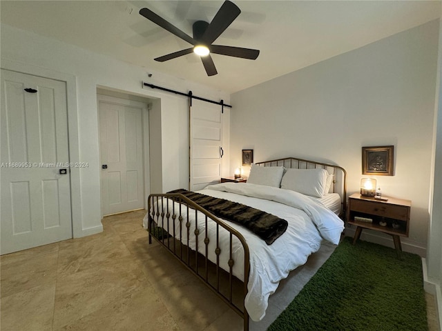 bedroom with a barn door and ceiling fan