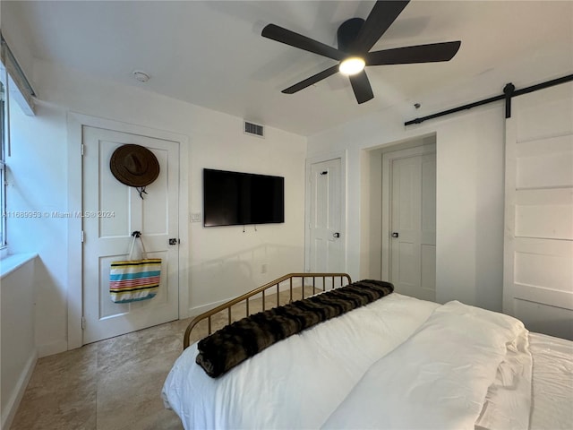 bedroom with a barn door and ceiling fan