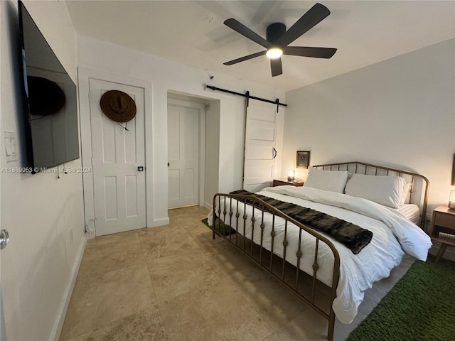 bedroom featuring a barn door and ceiling fan