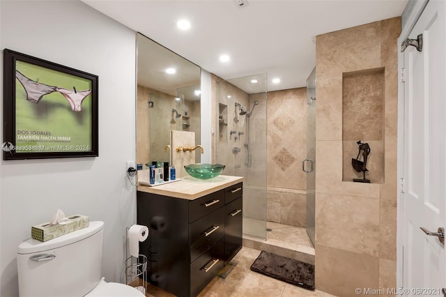 bathroom with vanity, tile patterned flooring, toilet, and an enclosed shower