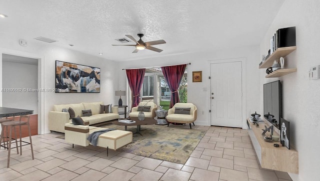 living room with a textured ceiling and ceiling fan