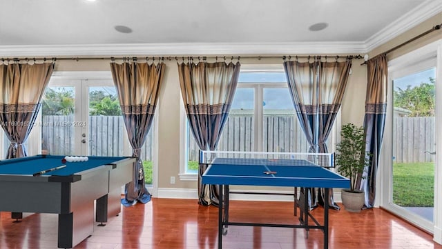 recreation room featuring plenty of natural light, wood-type flooring, and crown molding