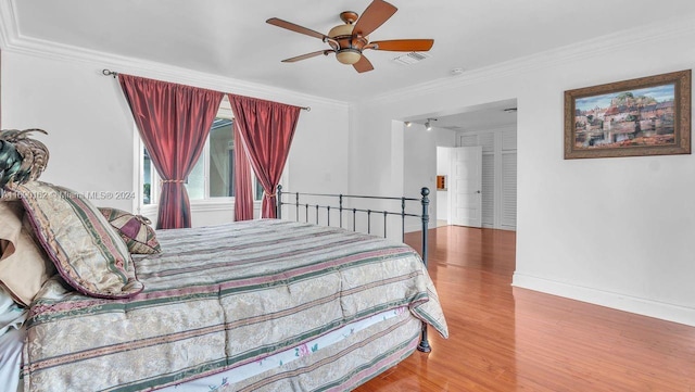 bedroom with hardwood / wood-style flooring, ceiling fan, and crown molding