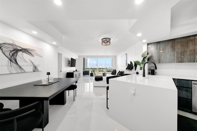 kitchen with recessed lighting, a sink, open floor plan, light countertops, and modern cabinets