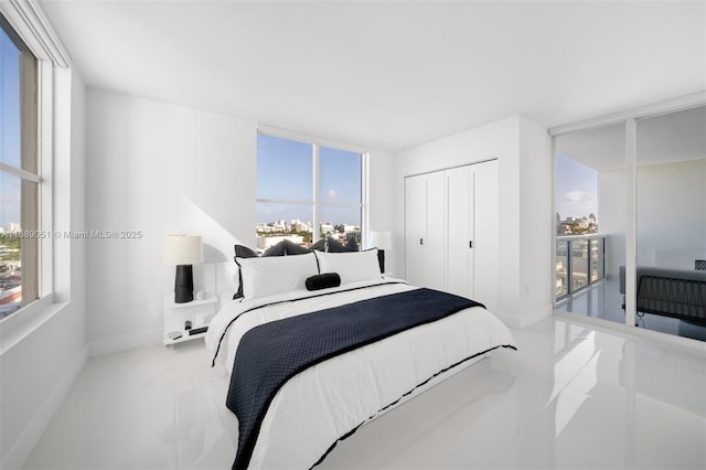 bedroom with baseboards, a wall of windows, and a closet