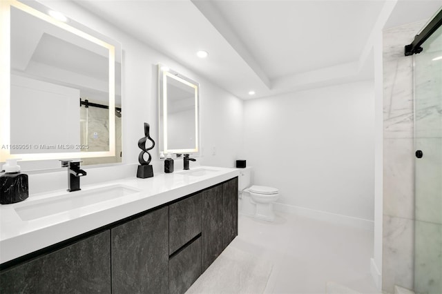 bathroom featuring a raised ceiling, double vanity, a sink, and toilet