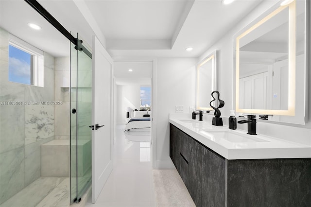 full bath with ensuite bathroom, double vanity, a sink, and a marble finish shower