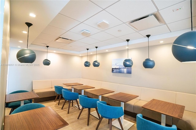 dining area featuring a paneled ceiling, visible vents, and light wood-style flooring