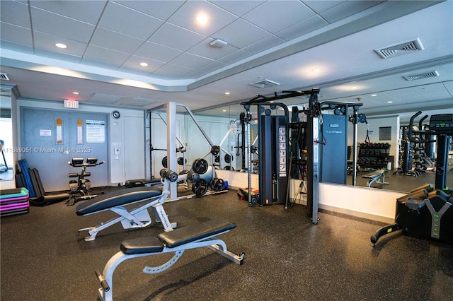 workout area with a tray ceiling, a drop ceiling, and visible vents