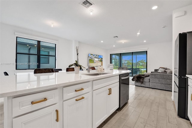 kitchen featuring light hardwood / wood-style floors, light stone counters, dishwasher, sink, and white cabinetry