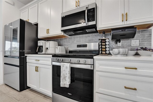 kitchen with white cabinetry, backsplash, and stainless steel appliances