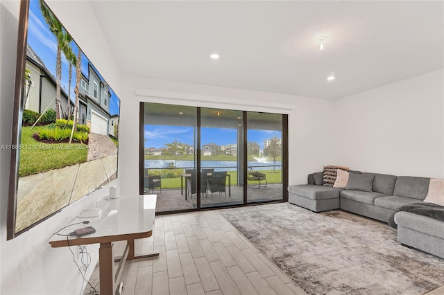 living room featuring hardwood / wood-style floors, a wealth of natural light, and a water view