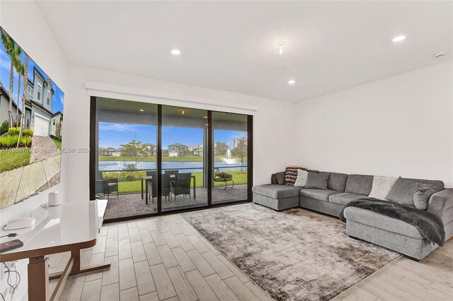 living room featuring a water view and light wood-type flooring