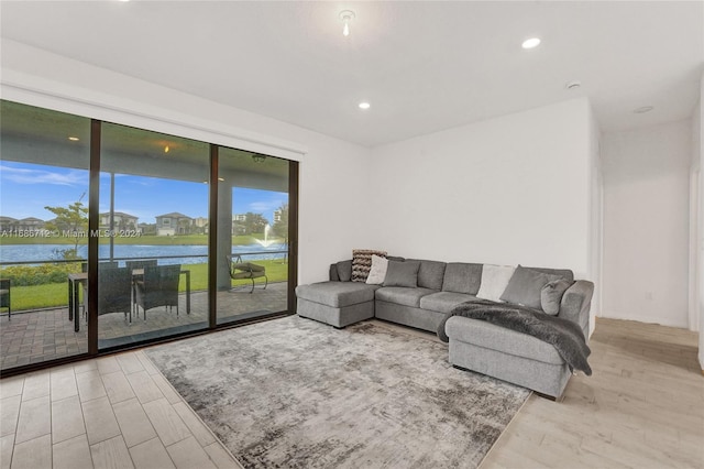 living room with a water view and light hardwood / wood-style flooring