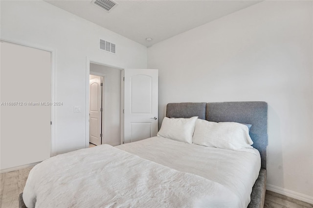 bedroom featuring light wood-type flooring and vaulted ceiling