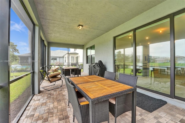 sunroom / solarium featuring a water view