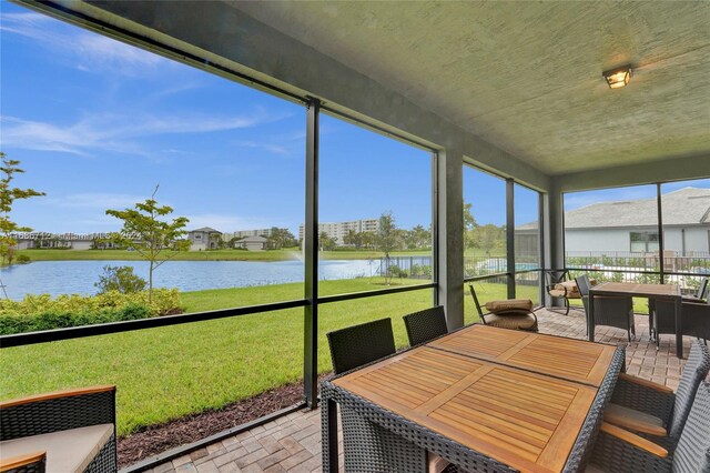 sunroom / solarium featuring a water view