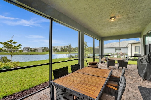 sunroom / solarium featuring a wealth of natural light and a water view