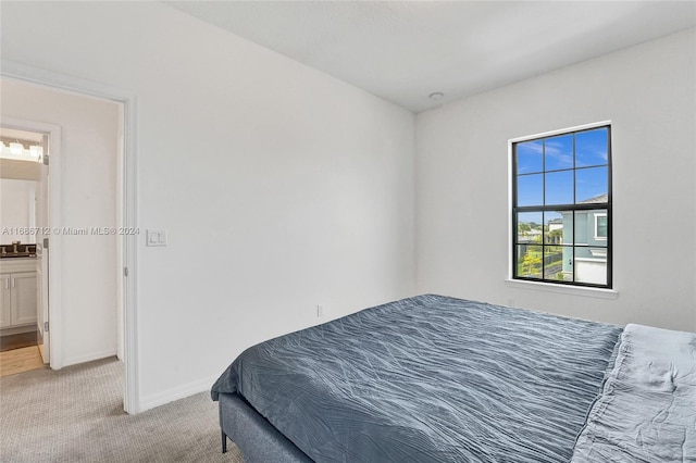 carpeted bedroom featuring ensuite bath