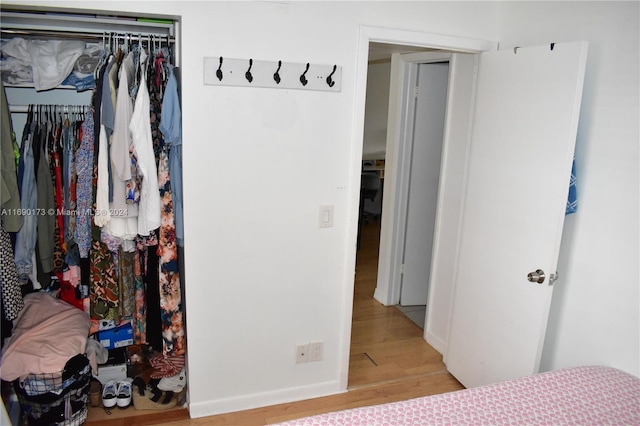 bedroom with light hardwood / wood-style flooring and a closet