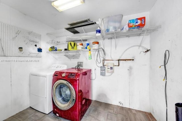 washroom with parquet flooring and washer and dryer