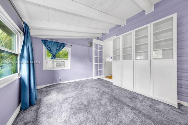 carpeted empty room featuring lofted ceiling with beams, a wealth of natural light, and wood ceiling