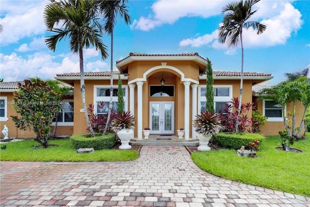 mediterranean / spanish house featuring french doors and a front yard