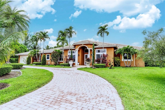 mediterranean / spanish house with a front lawn and a garage