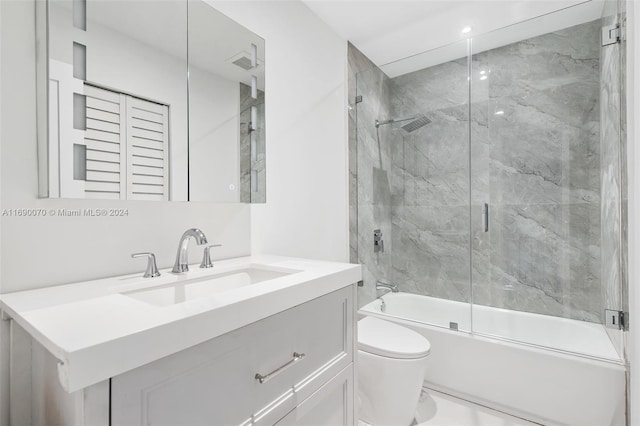 full bathroom featuring toilet, vanity, and enclosed tub / shower combo