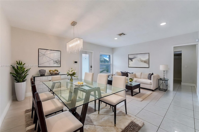 tiled dining room featuring an inviting chandelier