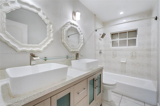 full bathroom featuring toilet, vanity, tiled shower / bath, and tile patterned floors