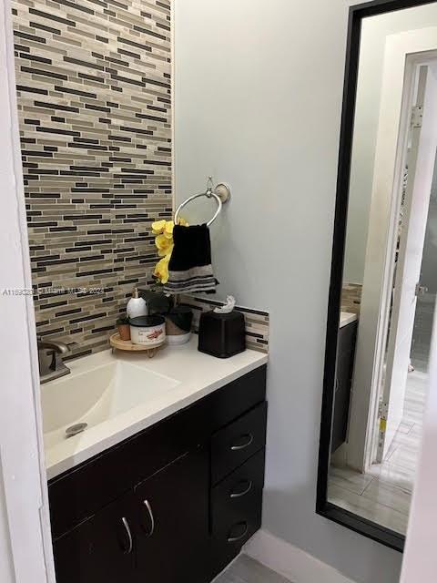 bathroom featuring vanity and tasteful backsplash