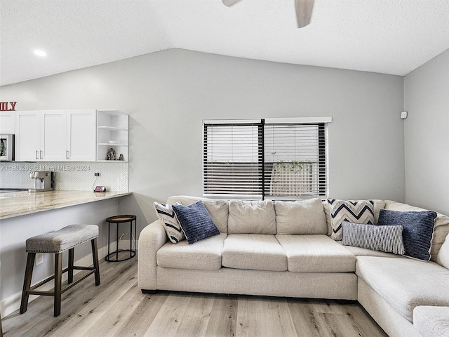 living room featuring light wood-type flooring, lofted ceiling, and ceiling fan