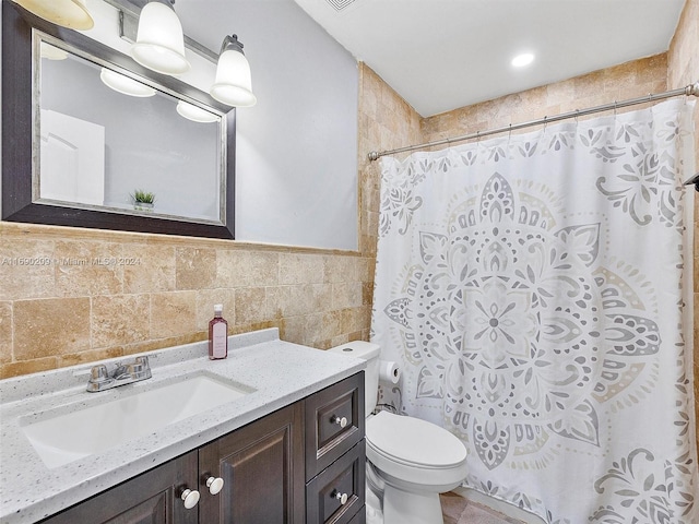 bathroom with tile walls, vanity, toilet, and a shower with shower curtain