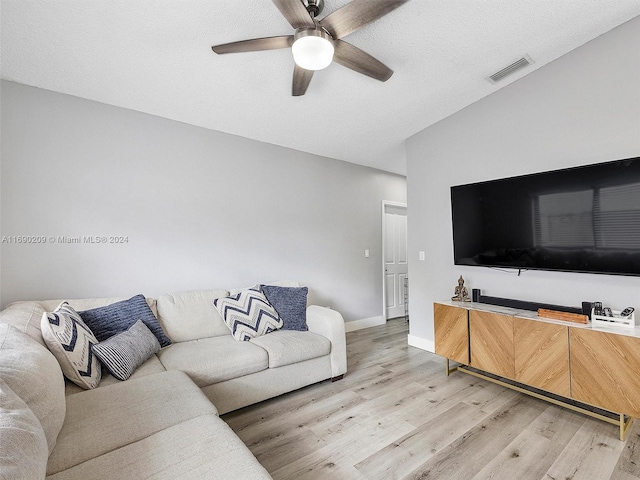 living room featuring a textured ceiling, lofted ceiling, hardwood / wood-style flooring, and ceiling fan