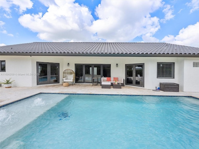 view of swimming pool featuring french doors, an outdoor living space, and a patio area