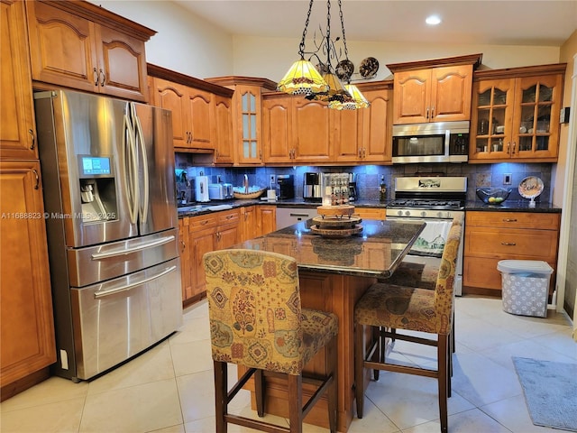 kitchen with backsplash, a kitchen island, a kitchen bar, and stainless steel appliances