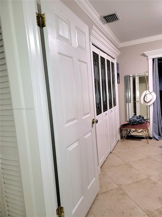 corridor featuring light tile patterned floors and ornamental molding