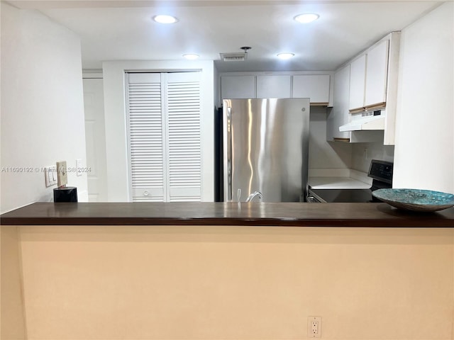 kitchen with kitchen peninsula, white cabinets, and appliances with stainless steel finishes