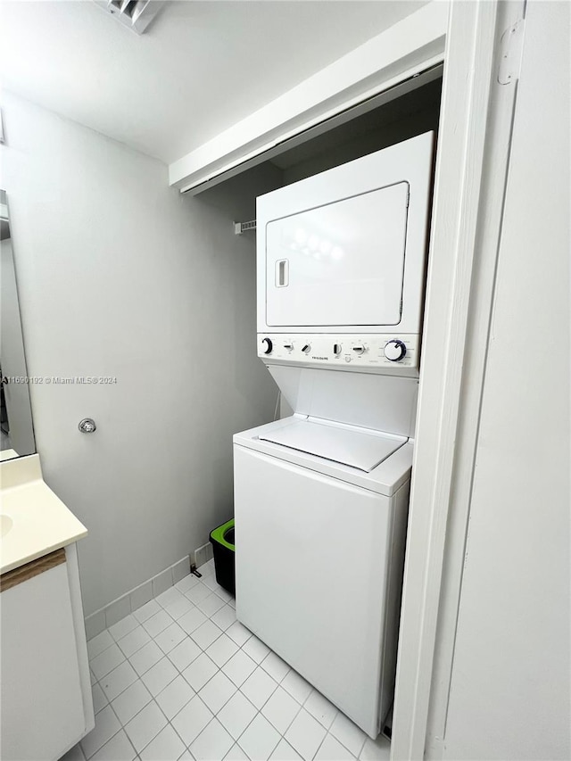 washroom with light tile patterned floors and stacked washer and dryer