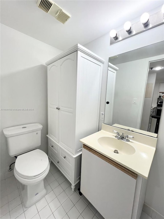 bathroom featuring toilet, vanity, and tile patterned floors