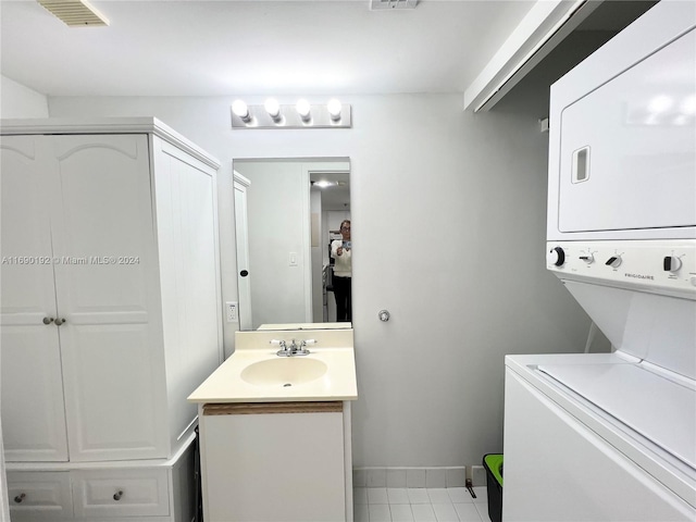 bathroom featuring tile patterned flooring, stacked washer / drying machine, and vanity